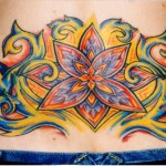 custom color glowing flower lower back tattoo for women at Majestic NYC