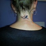 bird black silhouette on branch neck tattoo design Majestic Tattoo NYC