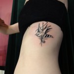 geometric black bird rib tattoo